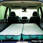 차박에 적합한 차량 추천 - A cozy interior of a modern minivan designed for car camping in Japan, showing a fully flat rear sea...